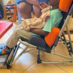 Photo of a child eating in the SPOON chair in Uganda, with face obscured