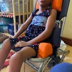 Photo of a child eating in the SPOON chair in Uganda, with face obscured